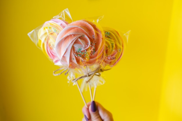 Una mujer sosteniendo un caramelo de colores en la mano.