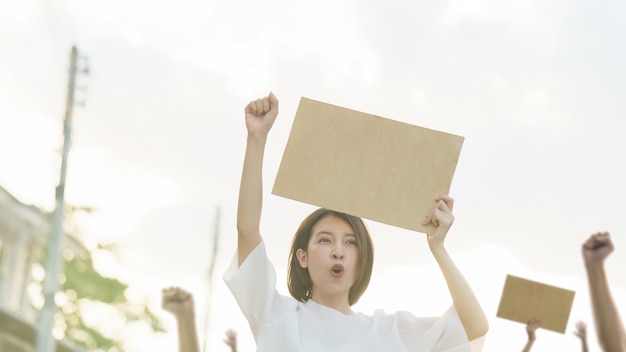 Mujer sosteniendo un cartel en blanco para poner el texto en protesta