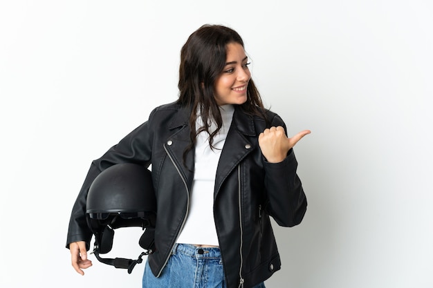 Mujer sosteniendo un casco de motocicleta aislado sobre fondo blanco apuntando hacia el lado para presentar un producto