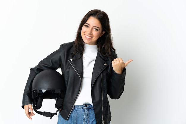 Mujer sosteniendo un casco de motocicleta aislado sobre fondo blanco apuntando hacia el lado para presentar un producto