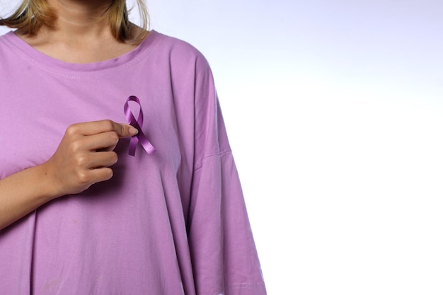 Mujer sosteniendo una cinta morada para conmemorar el día del cáncer