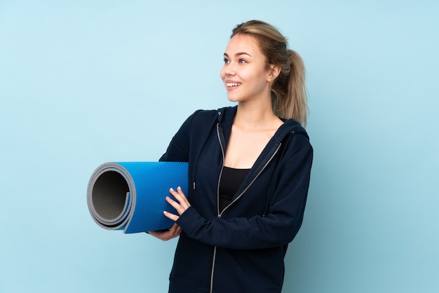 Mujer sosteniendo una colchoneta deportiva