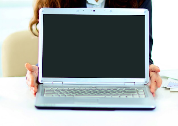 Mujer sosteniendo una computadora portátil.