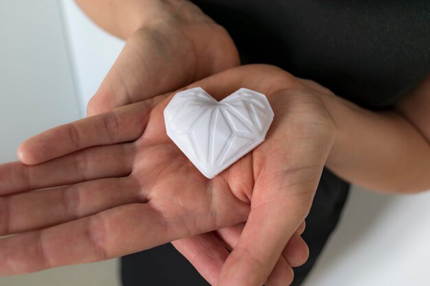 Mujer sosteniendo corazón blanco impreso en 3d Ideal para diversos conceptos amor y salud gratitud y caridad ya sea tecnología
