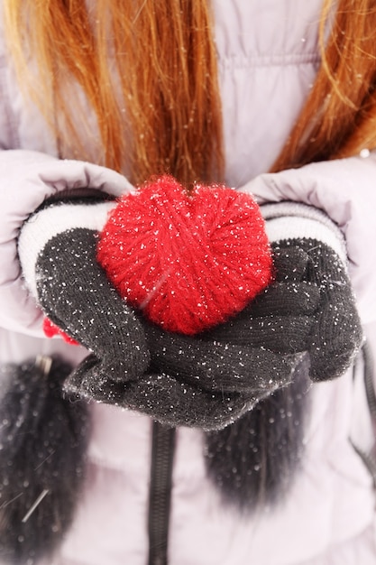 Foto mujer sosteniendo corazón de lana roja en la mano
