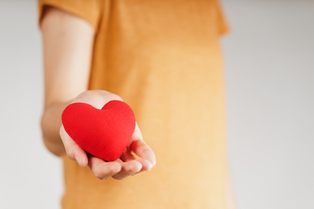 Mujer sosteniendo corazón rojo, amor, seguro médico, donación, voluntario de caridad feliz, día mundial de la salud mental, día mundial del corazón, día de san valentín