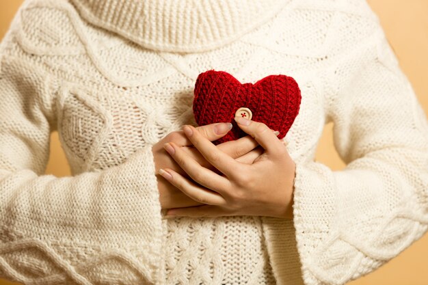 mujer sosteniendo corazón rojo en el pecho