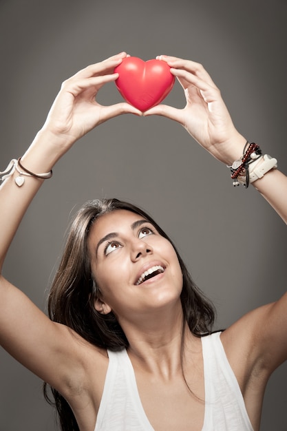 mujer sosteniendo un corazón rojo