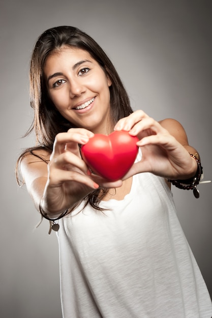 mujer sosteniendo un corazón rojo