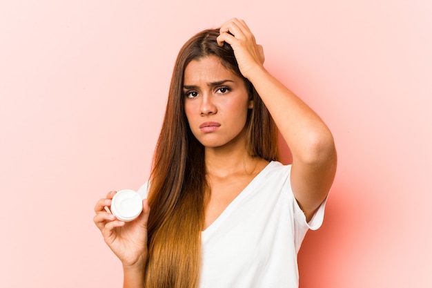 Mujer sosteniendo una crema hidratante