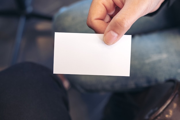 Una mujer sosteniendo y dando una tarjeta de presentación vacía en blanco a alguien