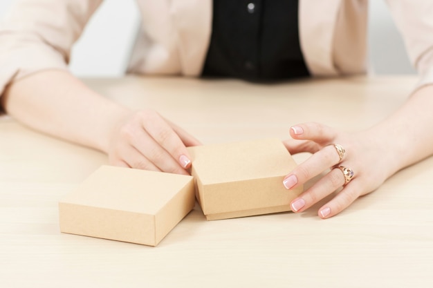 Mujer sosteniendo dos cajas de cartón en la mesa