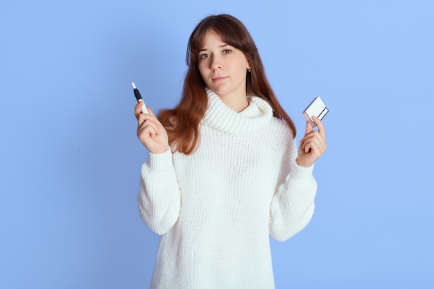 Mujer sosteniendo e-cigarrillo y palo en azul