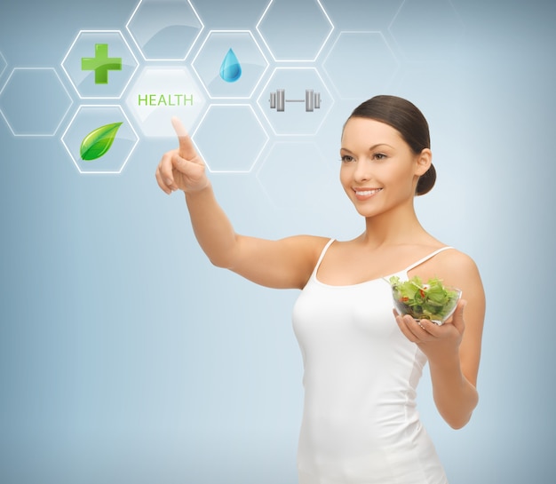 Mujer sosteniendo ensalada y trabajando con menú en pantalla virtual