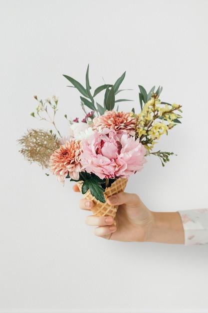 Foto mujer sosteniendo flores en un cono de helado