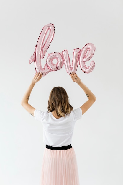 Mujer sosteniendo un globo de papel de amor