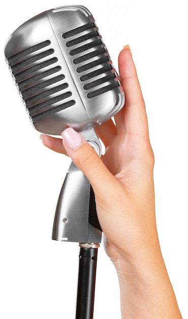Mujer sosteniendo gran micrófono retro para cantar