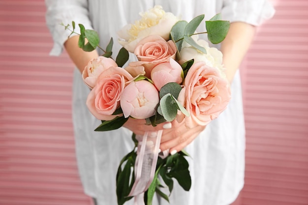 Mujer sosteniendo hermoso ramo de flores sobre fondo de pantalla rosa