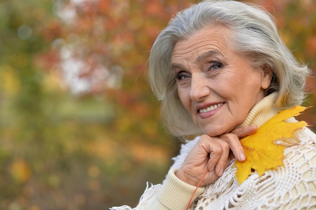 Mujer sosteniendo hoja de otoño