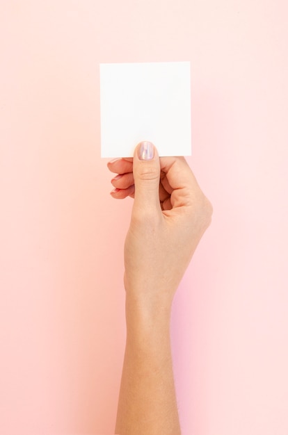 Mujer sosteniendo la hoja de papel en blanco