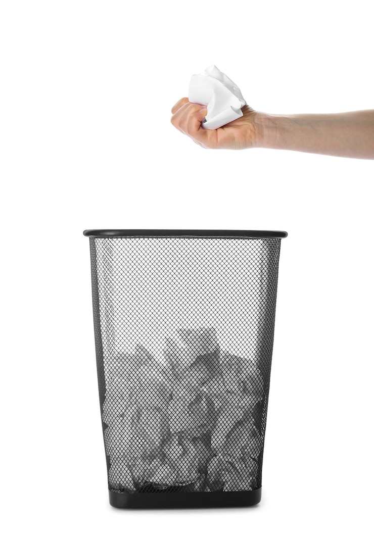 Foto mujer sosteniendo hojas de papel arrugadas sobre collage de papelera