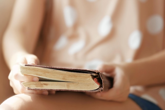 Mujer sosteniendo un libro viejo en casa