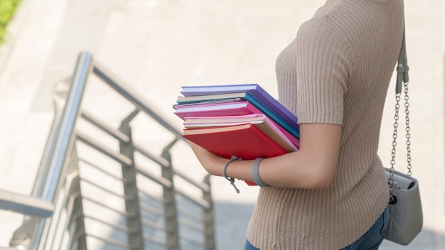 Foto mujer sosteniendo libros en las escaleras