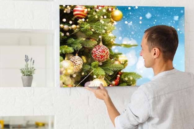 mujer sosteniendo un lienzo fotográfico con una imagen de navidad.