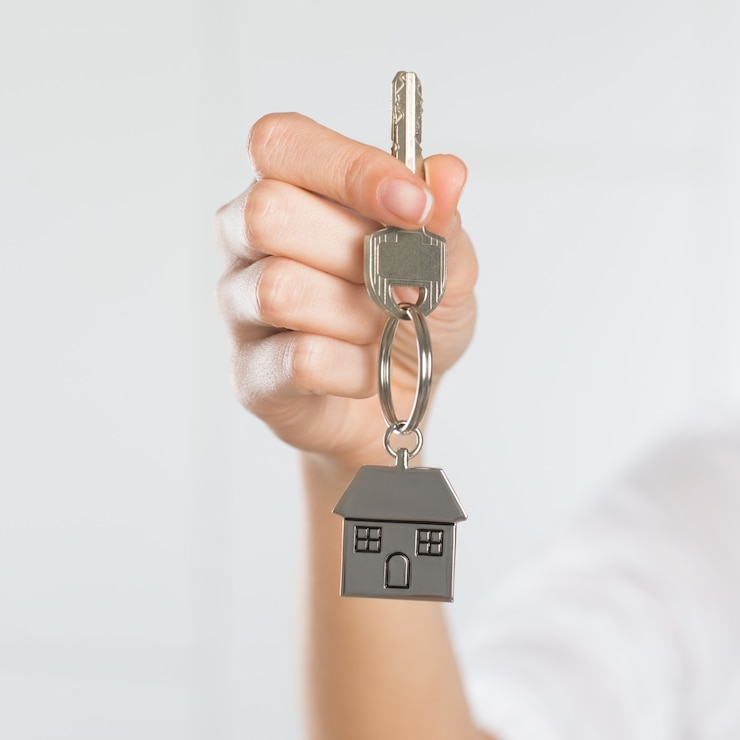 Foto mujer sosteniendo la llave de su nueva casa