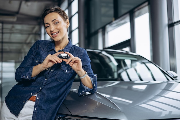 Mujer sosteniendo las llaves del coche de un coche nuevo