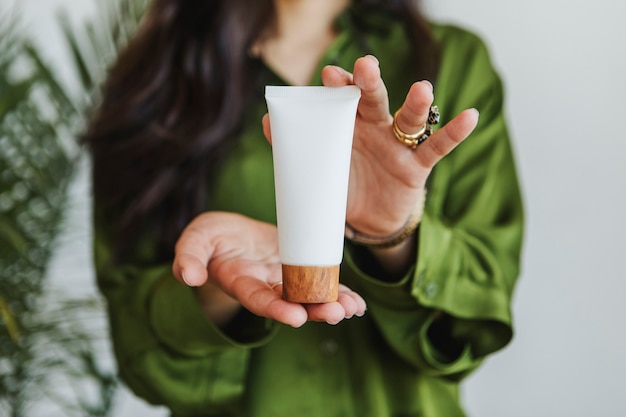 Mujer sosteniendo loción con ambas manos