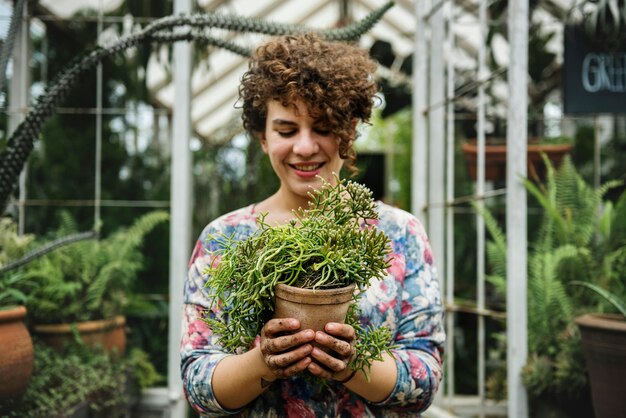 Mujer sosteniendo una maceta de plantas