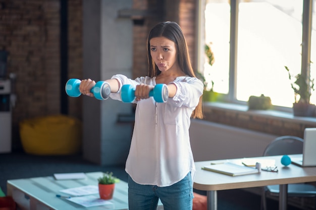 Mujer sosteniendo mancuernas mientras hace ejercicio