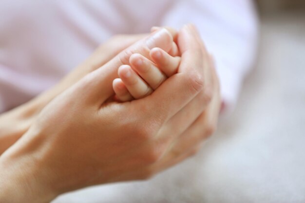 Foto mujer sosteniendo la mano del bebé pequeño