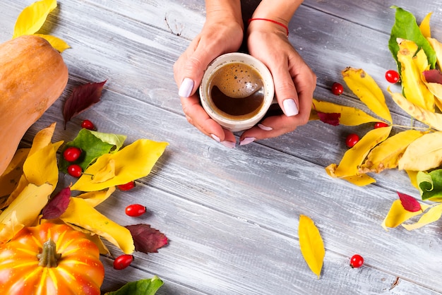 Mujer sosteniendo en las manos café caliente