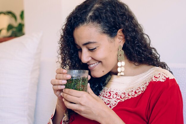 Mujer sosteniendo con las manos té verde árabe