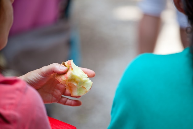 Mujer sosteniendo una manzana roja mordida