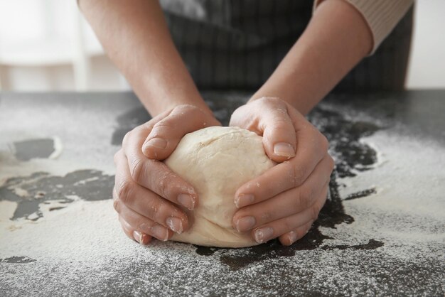 Mujer sosteniendo masa en la mesa primer plano