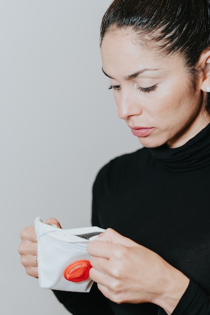 Mujer sosteniendo una mascarilla