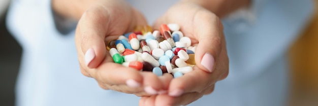Mujer sosteniendo un montón de medicamentos coloridos en la palma para el tratamiento