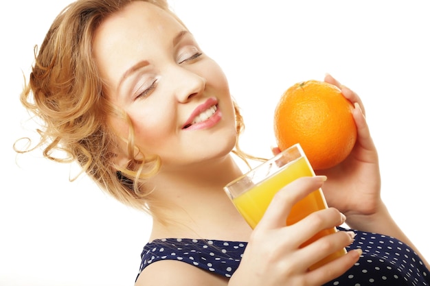 Mujer sosteniendo naranja y jugo sobre blanco