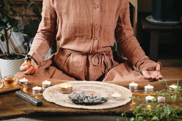 Mujer sosteniendo palo santo durante la meditación