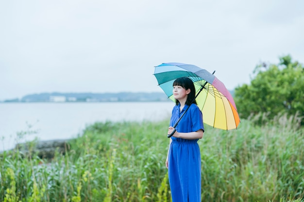 Una mujer sosteniendo un paraguas de colores bajo la lluvia