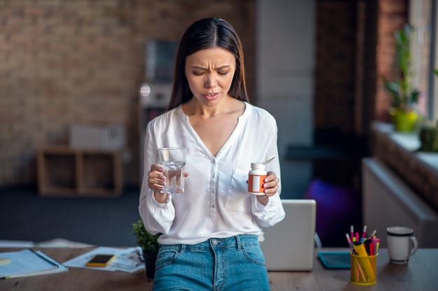 Mujer sosteniendo pastillas en sus manos