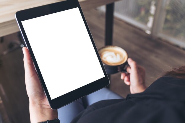 una mujer y sosteniendo la pc de la tableta negro con pantalla de escritorio en blanco y café