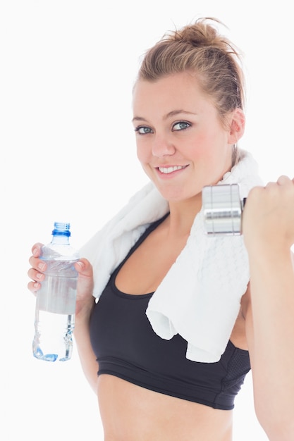 Mujer sosteniendo pesas y una botella de agua