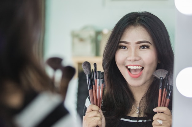 Mujer sosteniendo un pincel de maquillaje