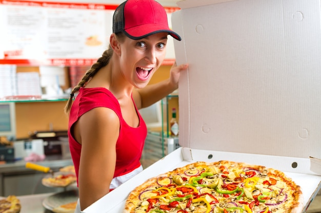 Mujer sosteniendo una pizza entera en la mano