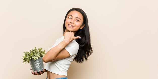 Mujer sosteniendo una planta en estudio