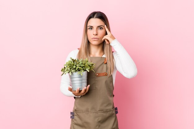 Mujer sosteniendo una planta en estudio